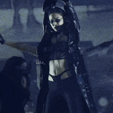 a woman wearing sunglasses and a crop top with the word who written on it