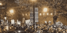 a large crowd of people holding signs including one that says black lives matter