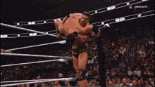 two men are wrestling in a ring and the peacock logo is visible