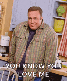 a man in a plaid shirt is standing in a kitchen with the words " you know you love me " below him