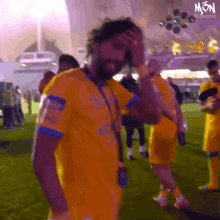 a man in a yellow jersey with the word mon on the bottom right