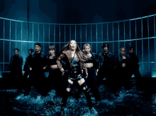 a group of dancers are standing in front of a blue wall