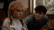 a boy and a girl are looking out of a window