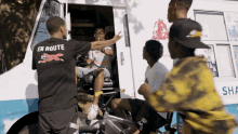 a man wearing a shirt that says en route is talking to another man