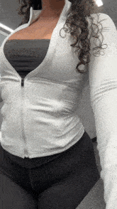 a woman with curly hair wearing a white jacket