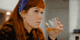 a woman with red hair is drinking from a glass with haynah @ discord written in the corner