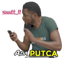 a man wearing a green shirt with the word wild on it looks at his phone