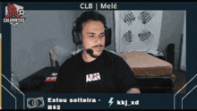 a man wearing headphones is sitting in front of a bed and says clb mele