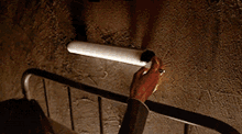 a person is reaching for a light that is on the wall