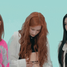 a woman with long red hair is holding a book that says ' i 'm sorry ' on it