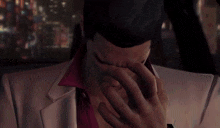 a man covering his face with his hands in a car