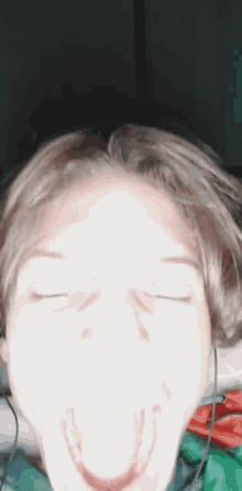 a close up of a person making a funny face with their eyes closed