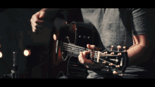 a man is playing an acoustic guitar with a taylor logo on the neck