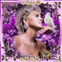 a woman in a purple dress is holding a white bird on her finger .