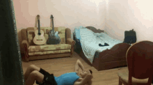 two men are doing sit ups in a room with a guitar on the couch