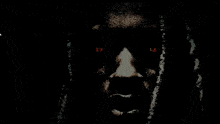 a close up of a man 's face with dreadlocks and red eyes