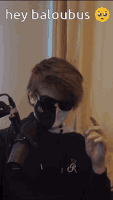 a man wearing sunglasses and a mask is smoking a cigarette .