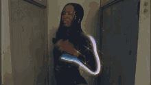 a woman is standing in a hallway with a light coming out of her back .