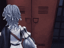 a person with dreadlocks is standing in front of a red locker