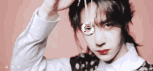 a woman is holding a necklace in front of her face