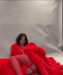 a woman is wearing a red fur coat and red stockings