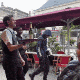 a waiter is carrying a tray with a bottle of champagne and two glasses on it