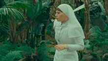 a nun is smoking a cigarette in a jungle