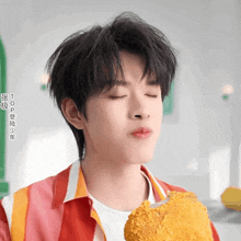 a close up of a person eating a piece of fried food with chinese writing on it