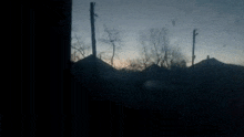 a blurry picture of a sunset with trees in the background