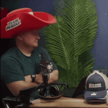 a man wearing a red cowboy hat says team penske
