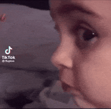 a close up of a baby 's face with a tiktok icon on the bottom right corner .