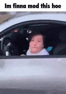 a woman is driving a car with a caption that says im finna mod this hoe .