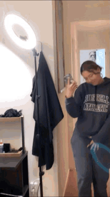 a girl wearing a russell athletic hoodie takes a selfie