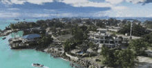 an aerial view of a tropical island with houses and boats in the water