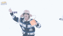 a man wearing a hat and a sweater is holding a snow shovel in his hand .