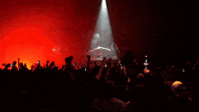a crowd of people at a concert with their arms in the air