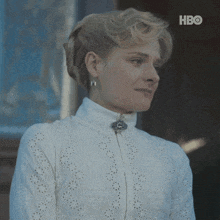 a woman in a white dress with a hbo logo on the bottom right