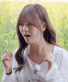 a girl with a surprised look on her face is wearing a white shirt with a bear on it