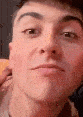 a close up of a man 's face with a slight smile