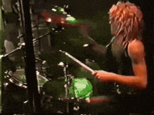 a man with dreadlocks is playing a drum set