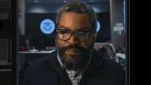 a man with glasses and a beard stands in front of a sign that says u.s. department of homeland security