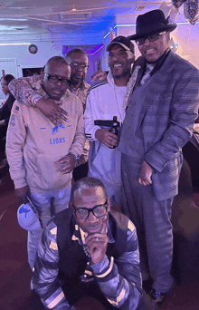 a group of men posing for a picture one of whom is wearing a lions sweatshirt