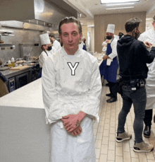 a man in a white chef 's coat with the letter y on his chest
