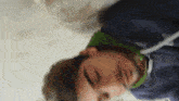 a man in a blue jacket is laying on his back with his eyes closed