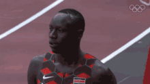 a man stands on a track wearing a kenya jersey