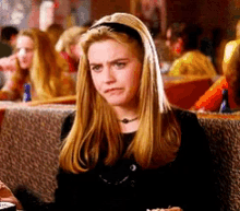 a woman wearing a black headband is sitting in a restaurant