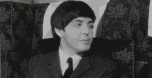 a man in a suit and tie is sitting in a chair with the word morning written on it .