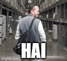 a man is walking through a warehouse with a bag that says hai on it