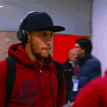 a man wearing headphones and a red hoodie that says mes