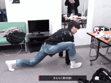 a man stretches his legs in front of a sign that says & tea